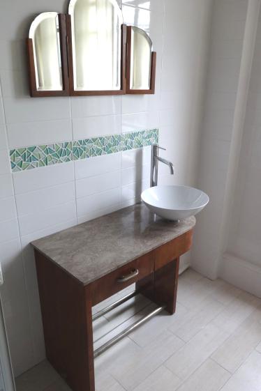 Meuble-vasque créé à partir d'une coiffeuse ancienne et intégré dans la salle de