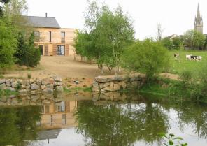 Vue de l'étang : La maison et le bourg, le clocher en point de repère des pièces