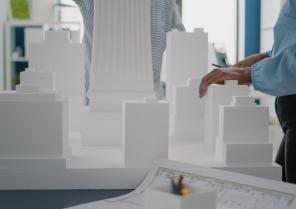 close-up-women-with-building-model-blueprints-plan-table-diverse-architects-working-with-maquette-industrial-sketch-design-construction-structure-strategy-project
