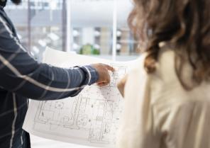 real-estate-expert-presenting-office-space-layout-woman-using-blueprints