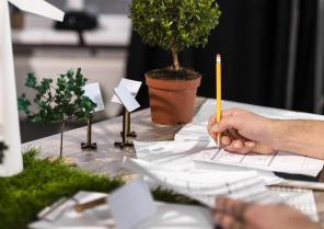 side-view-man-working-eco-friendly-wind-power-project-with-paper-plans